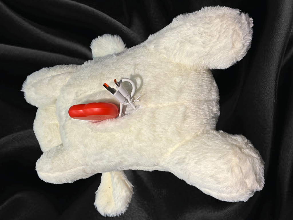 White plush dog toy showing heartbeat module placement in belly pouch